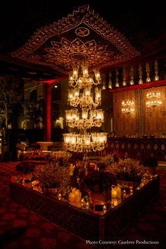 a chandelier hanging from the ceiling in a room with red walls and carpet