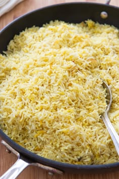 a pan filled with rice on top of a wooden table