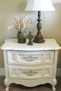 a white dresser with two vases and a lamp on top