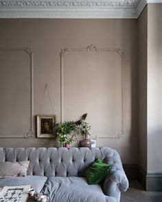 a living room filled with furniture and a painting on the wall next to a window