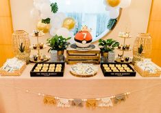 a table with desserts and balloons on it