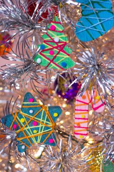 colorful ornaments are hanging from the christmas tree