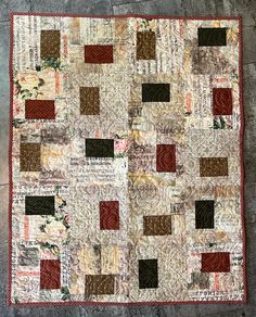 a patchwork quilt is displayed on the floor