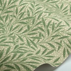 a green and white wallpaper with leaves on it