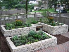 an outdoor garden area with brick walls and plants in the center, surrounded by landscaping