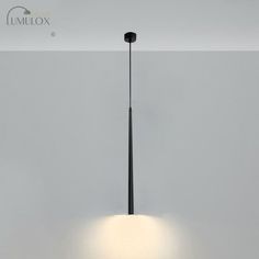 a light that is hanging from the ceiling in front of a white wall and floor