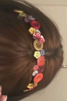 a close up of a person's hair with buttons in it