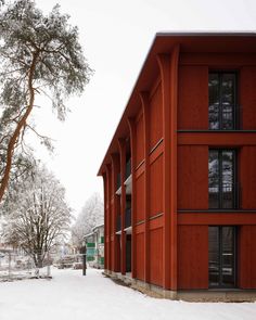 the building is red in color, and it has snow on the ground around it