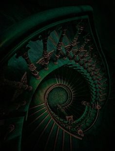 a spiral staircase in the dark with green lighting