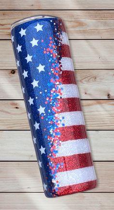 a red, white and blue glitter tumbler with the american flag painted on it