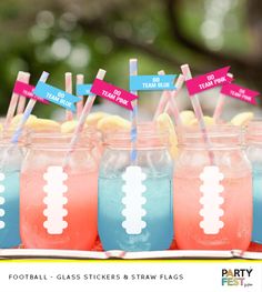 football themed drinks are lined up in mason jars with colorful straws and paper signs