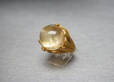 "Vintage Mid-Century Circa 1960 Constructed of Sterling Silver Accented with a Gold Plating / Vermeil  Containing 1 Focal Round Cabochon cut Genuine Earth-Mined Natural Citrine 'Sphere' weighing approximately 18.14 carats at approximately 15.4mm in diameter x 10.3mm in depth Secured in a Multi-Prong Setting NOTE:  Natural internal inclusions.. Not cracked.. Natural to stone.. Simply a characteristic of naturally earth-mined Gemstones..  *Citrine, along with Smoky Topaz & Cognac Diamond, is the b Citrine Sphere, Sphere Ring, Crystal Ball Ring, Gold Reserve, Cognac Diamonds, Smoky Topaz, Ring Crystal, Amber Ring, Citrine Ring