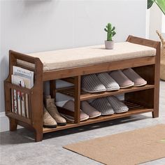 a wooden bench with several pairs of shoes on it next to a potted plant