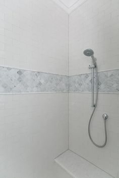 the shower head is mounted on the wall next to the bathtub and faucet