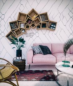 a living room with pink couches and bookshelves on the wall above them