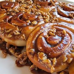 two cinnamon buns with nuts on top of them