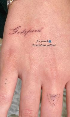 a person's hand with a small tattoo on it