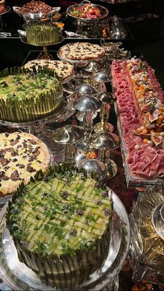 a buffet table filled with lots of different types of cakes and pies on plates