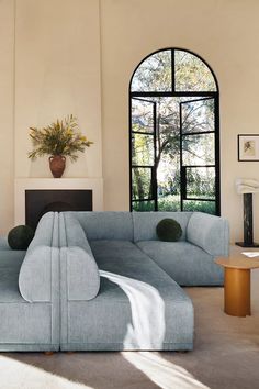 a living room filled with furniture next to a large window and a fireplace in front of it