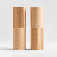 two wooden salt and pepper shakers sitting next to each other