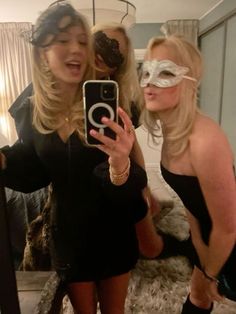 two women are taking a selfie in front of a mirror while wearing blindfolds