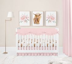 a baby's room with pink curtains and pictures on the wall, along with a white crib