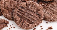 chocolate cookies are arranged on a white surface