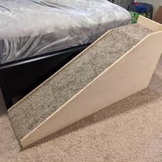 a bed that has been made and is sitting on the floor next to a box