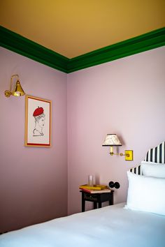 a room with a bed, lamp and pictures on the wall