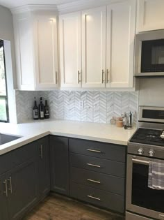 a kitchen with gray cabinets and white counter tops