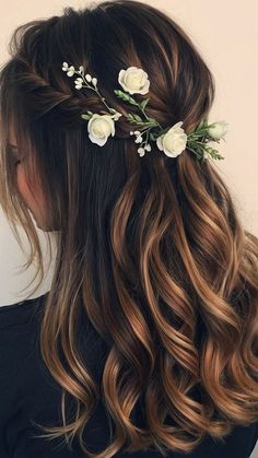 a woman with long hair and flowers in her hair is wearing a flowered half updo