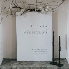 a welcome sign with white flowers on it