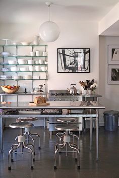 the kitchen is clean and ready to be used for cooking or baking, with stainless steel tables and stools