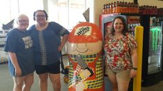 three women standing in front of a vending machine with a cartoon character on it