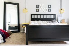 a bedroom with a bed, dresser and mirror on the wall next to each other