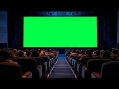 an empty theater with people watching a green screen