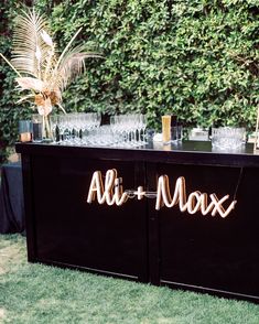 an outdoor bar set up with wine glasses and palm trees