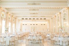 an elegant ballroom with white tables and chairs