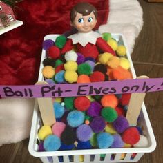 a basket filled with lots of pom poms on top of a wooden floor