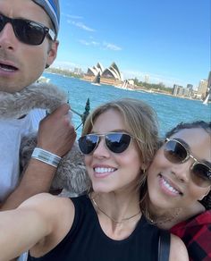 two women and a man taking a selfie with the sydney opera house in the background