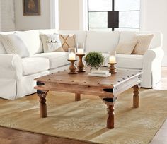 a living room with white couches and coffee table