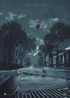 a red balloon floating in the air over a rain soaked street with buildings and trees