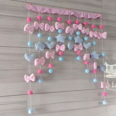 a pink and blue butterfly mobile hanging on the wall