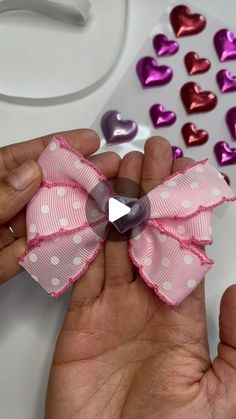 someone is holding a pink bow with hearts on it