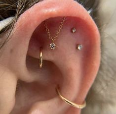 an ear with three piercings attached to it