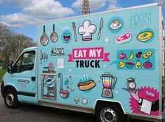 a food truck parked in front of the eiffel tower with stickers on it