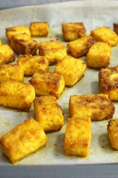 there are many square pieces of food on the baking sheet and it is ready to be cooked