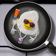 a frying pan with an egg and sunglasses on it