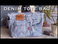 the denim tote bag is next to a potted plant