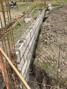 a motorcycle is parked on the side of a concrete block wall near a construction site